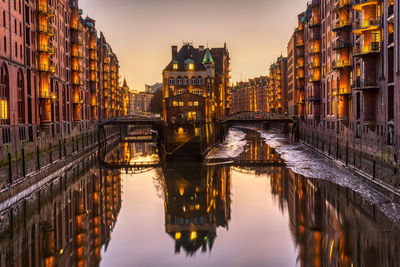 Bridge over river amidst buildings in city