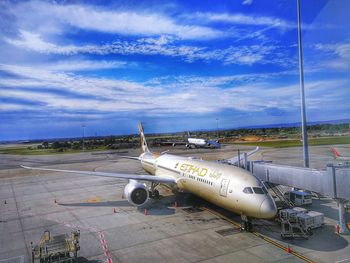 Airplane on airport runway against sky