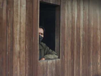 Portrait of man sitting on wooden windows