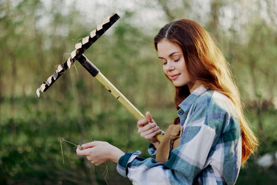 Smiling woman holding rake