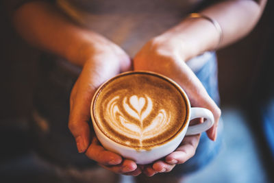 High angle view of hand holding coffee cup