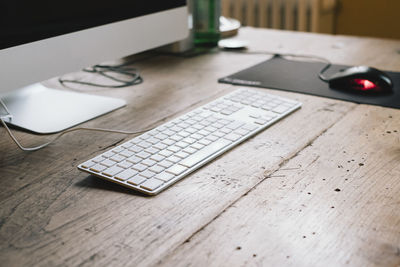 High angle view of keyboard by computer on table