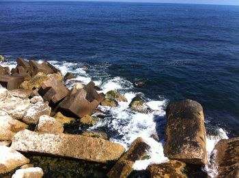 Rocks on sea shore against sky