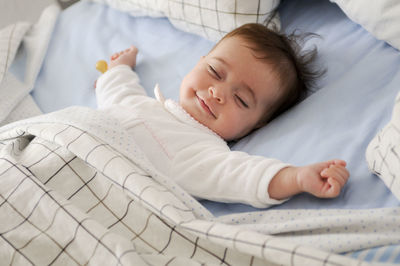 High angle view of baby sleeping on bed at home