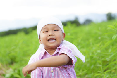 Portrait of smiling boy standing on field