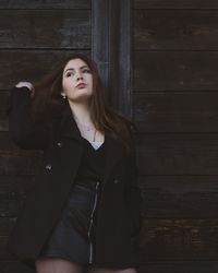 Portrait of woman standing against wall