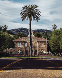 Road leading towards building against sky