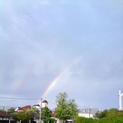 Low angle view of rainbow against cloudy sky