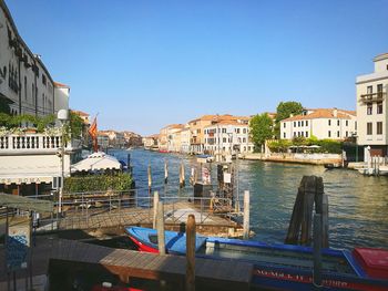 Boats in city against clear blue sky
