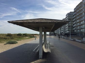 Empty road amidst buildings against sky