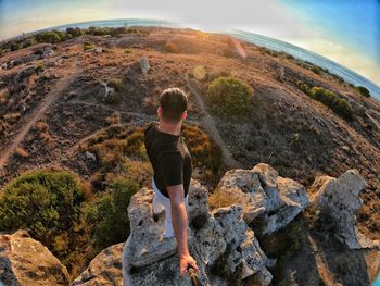 Rear view of man standing on rock