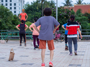 Rear view of people walking on footpath