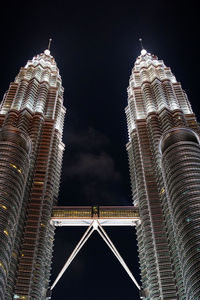 Close-up of kl petronas twin towers viewing from bottom at night.