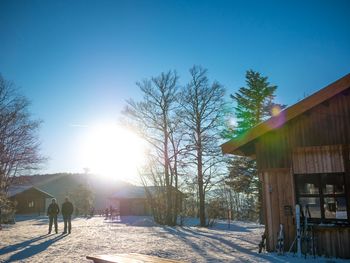 People on snow covered landscape against sky