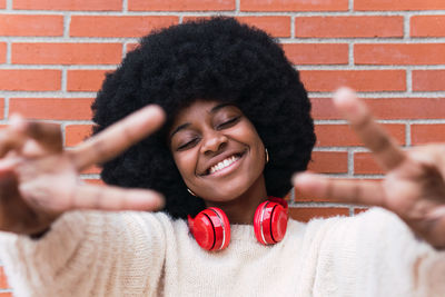 Portrait of young woman showing peace sign