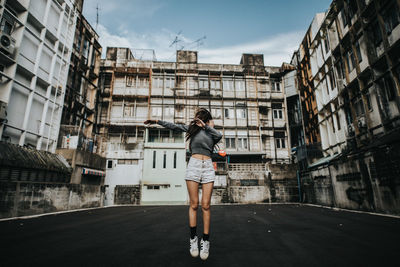 Woman standing against buildings in city