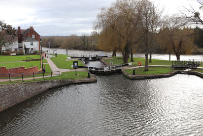 Scenic view of river by buildings against sky