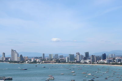 Sea by city buildings against sky