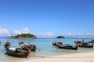 Boats moored on sea against sky