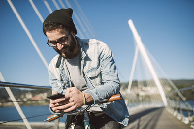 Young man riding on sunglasses against sky