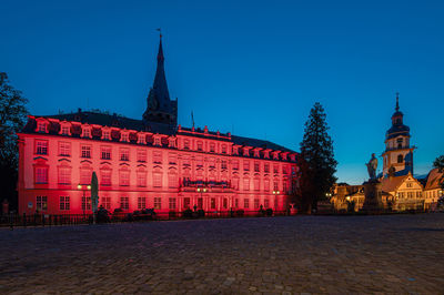 Illuminated building against blue sky at dusk