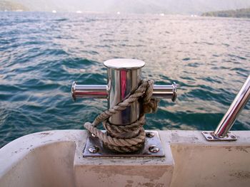 Close-up of rope tied on bollard in sea