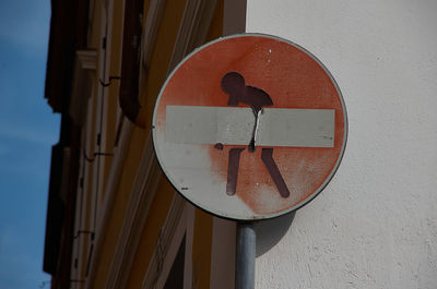 Low angle view of arrow sign on wall