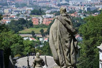 Rear view of statue amidst buildings in city