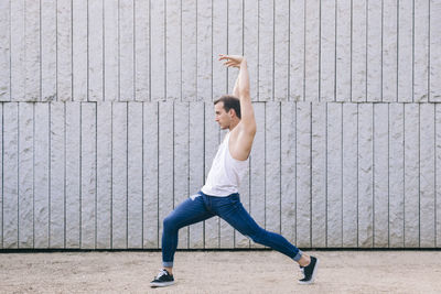 Full length portrait of man standing against wall