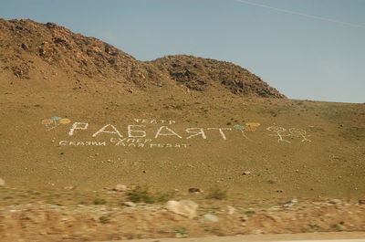 Text on mountain against sky