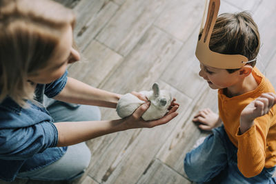 Mother showing bunny to son at home