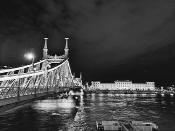 Illuminated bridge over river at night