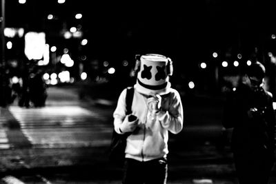 Full length of man standing on street at night