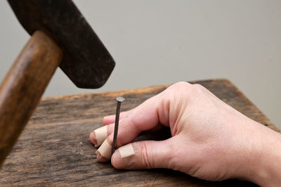 Motivation concept. man accident hurts his finger with a wood hammer