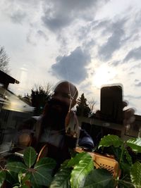 Low angle view of woman by tree against sky