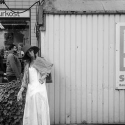 Young woman standing against wall