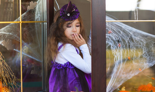 Cute girl in costume standing by door