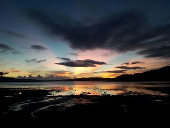 Scenic view of sea against dramatic sky during sunset