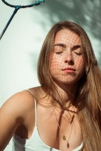 Close-up of beautiful young woman holding racket