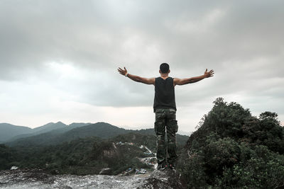 A man wearing a military uniform standing on mountain on mountain