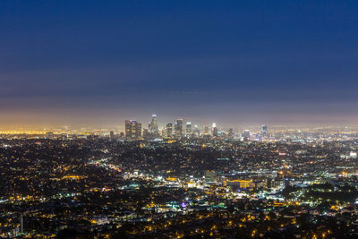 High angle view of illuminated buildings against sky at night