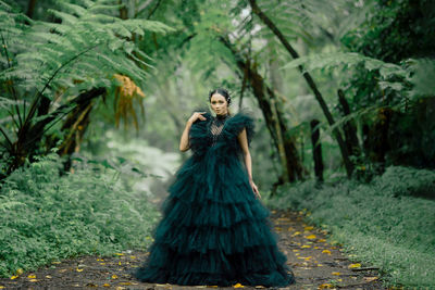 Portrait of woman standing by plants