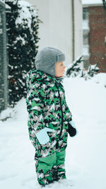 Rear view of boy standing in snow