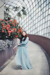 Portrait of woman standing by potted plants