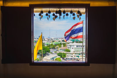 Multi colored flags on window of building