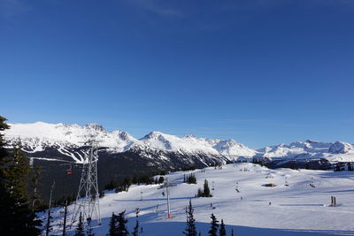 Scenic view of snowcapped mountains against clear blue sky