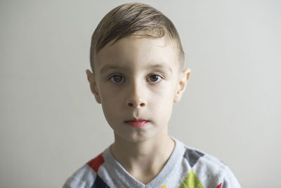 Close-up portrait of boy against white background