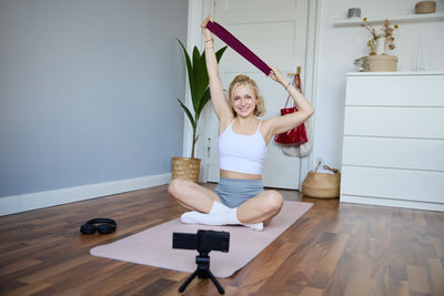 Rear view of young woman exercising in bathroom