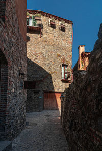 Alley amidst buildings in town against clear sky