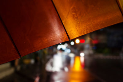 Close-up of wet illuminated metal during rainy season